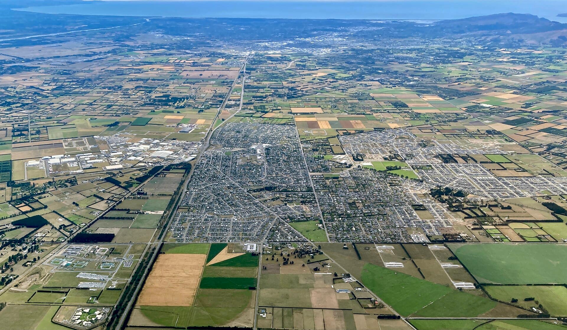 Rolleston, New Zealand: The settlement of Rolleston, New Zealand, from the air looking north-east towards Christchurch. Shipping warehouses can be seen north of State Highway 1, and the most recent suburban expansion to